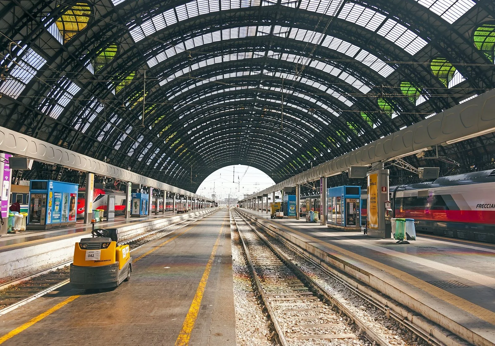 Binari e grande tettoia in ferro e vetro della stazione di Milano Centrale