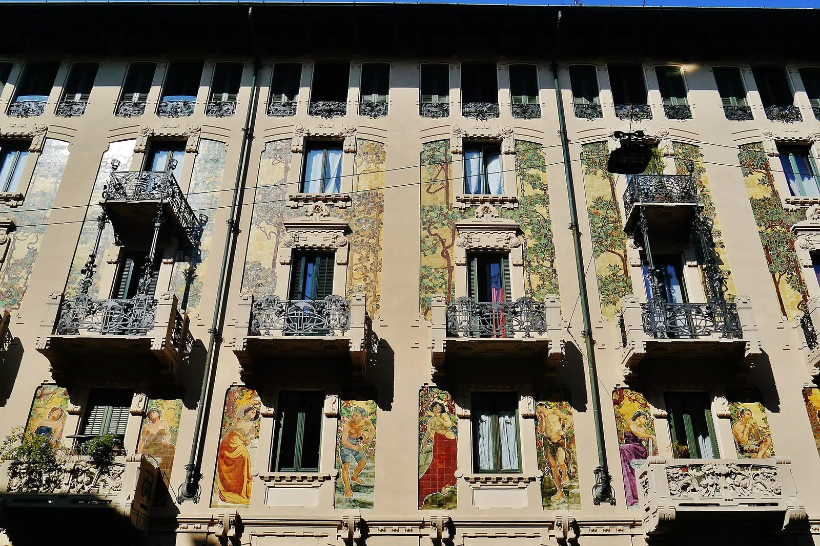 Facciata di Casa Galimberti in via Malpighi a Milano, con pannelli in ceramica dipinta e balconi in ferro battuto