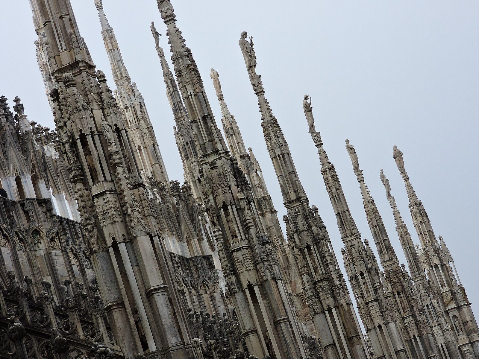 Guglie in marmo del Duomo di Milano con le statue in cima, viste dalle terrazze della cattedrale